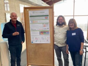NextGEM partners pose in front of the project's poster at the School of Bioelectromagnetism